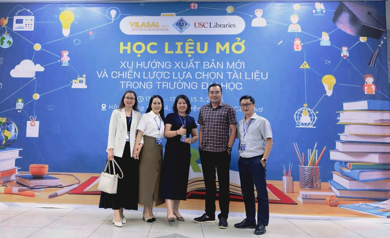 A group of people standing in front of a blue banner

Description automatically generated