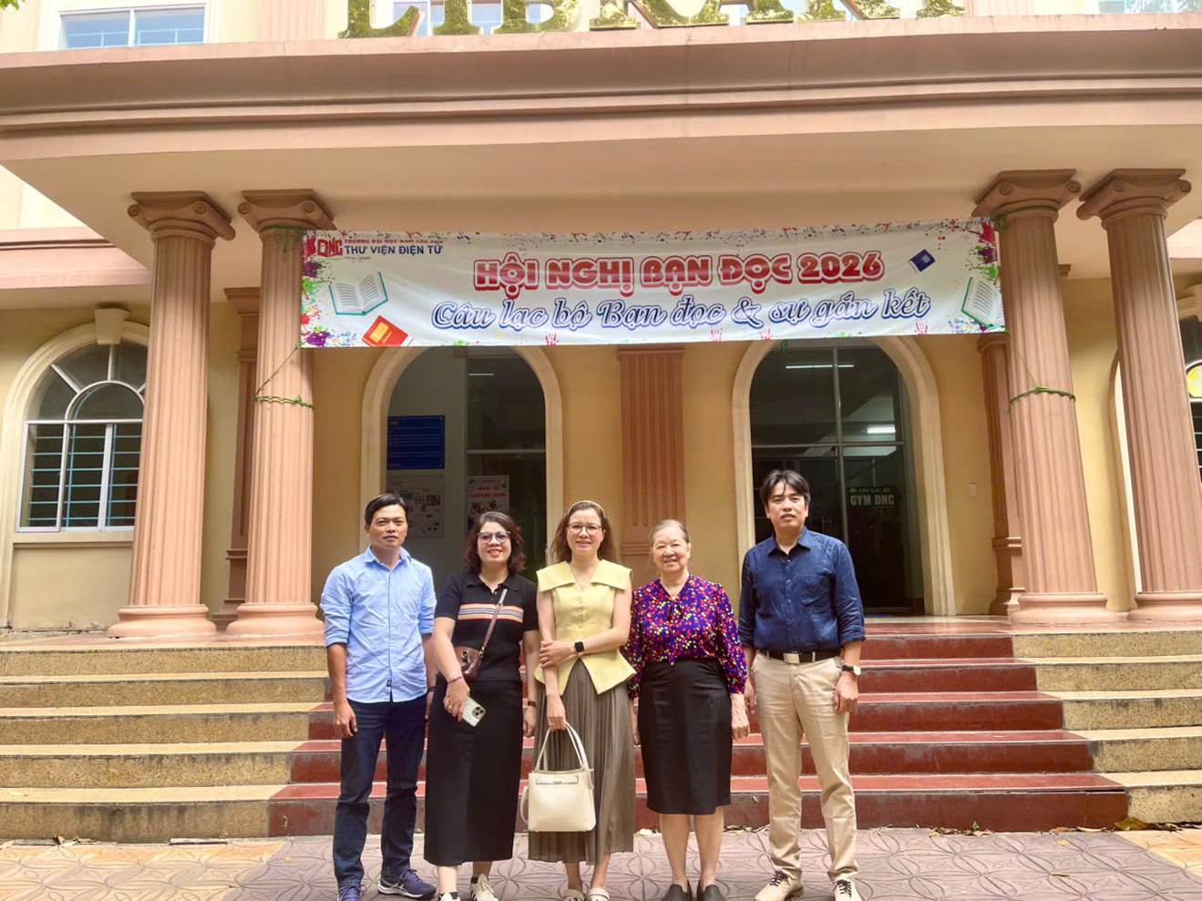 A group of people standing in front of a building

Description automatically generated